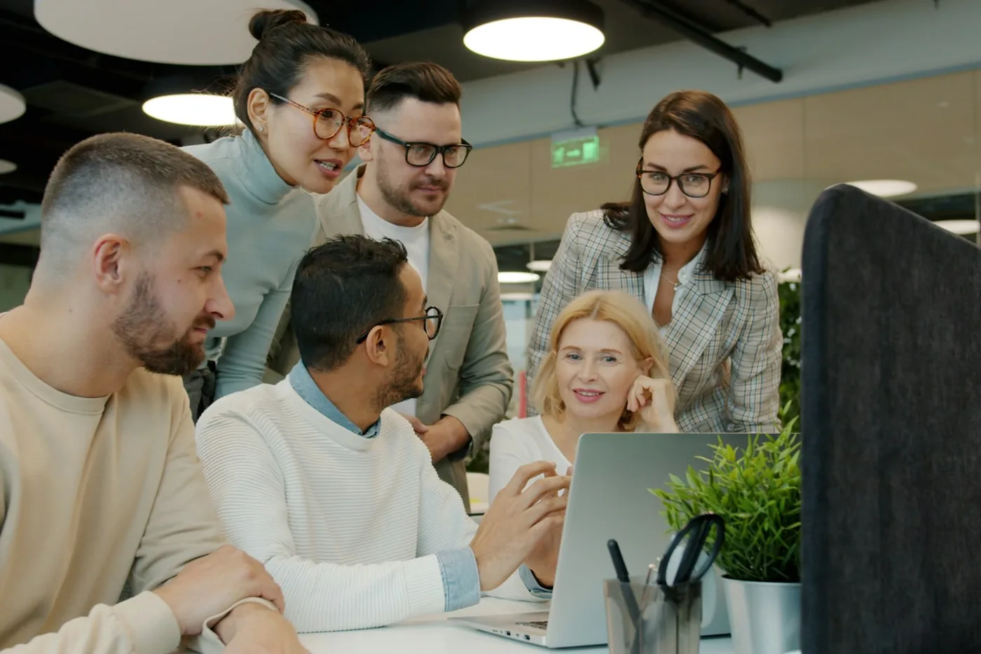 A team working together around a laptop